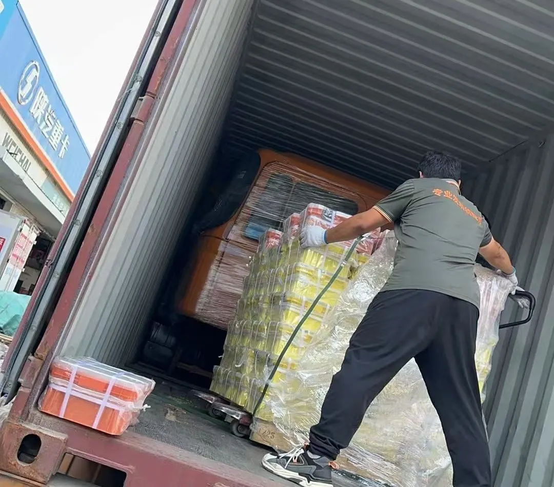 Loading palletized heavy truck spare parts into an export container at the warehouse