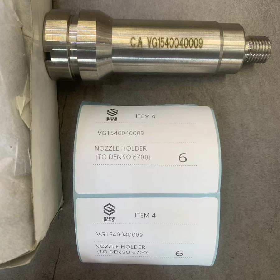 VG-prefix Sinotruk part number VG1540040009 stamped on a nozzle holder, with the packing label ITEM 4 NOZZLE HOLDER (TO DENSO 6700)