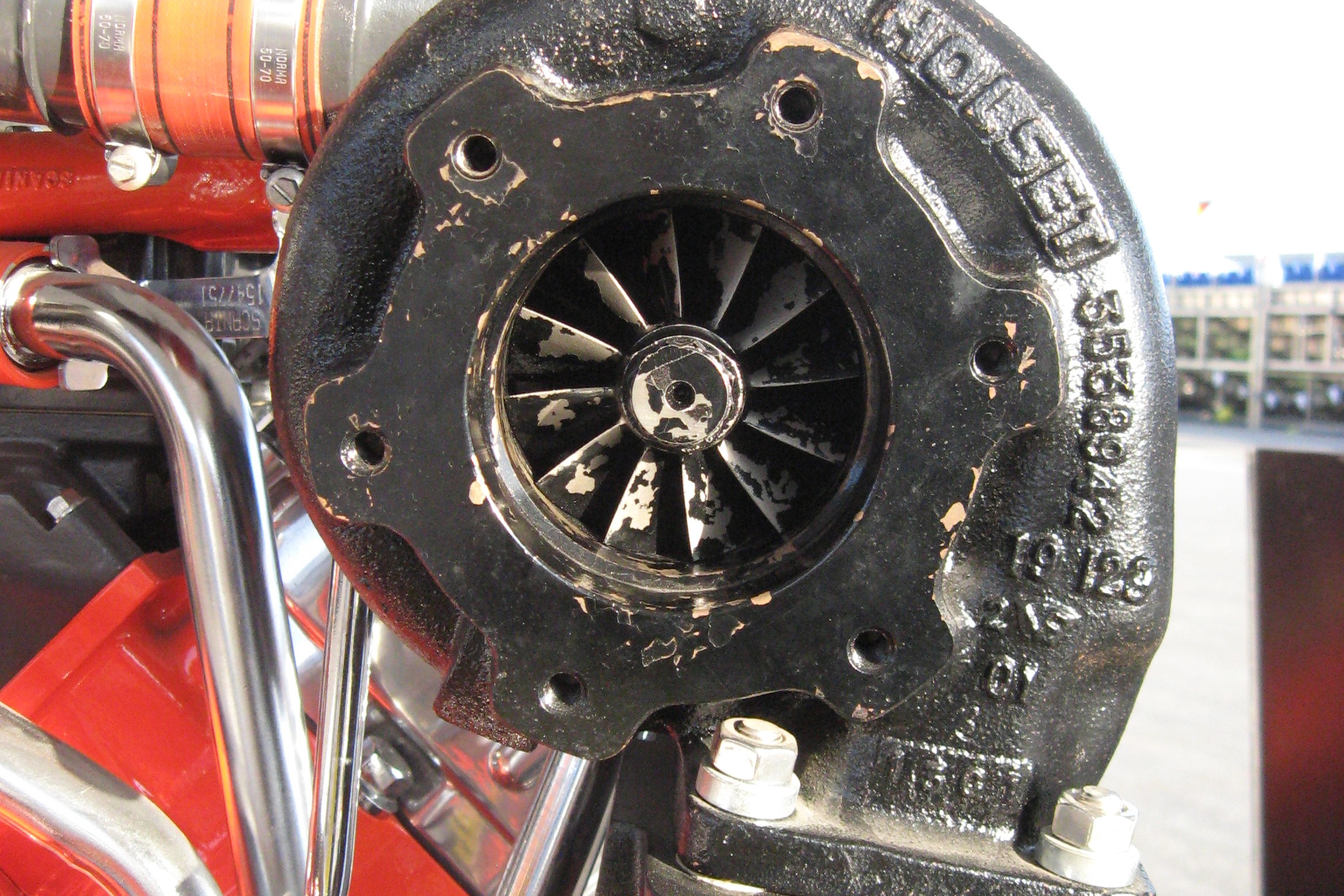 Close-up of the turbine wheel of a Holset turbocharger on a truck engine, the part an inspector checks for rubbing, cracks and blade damage