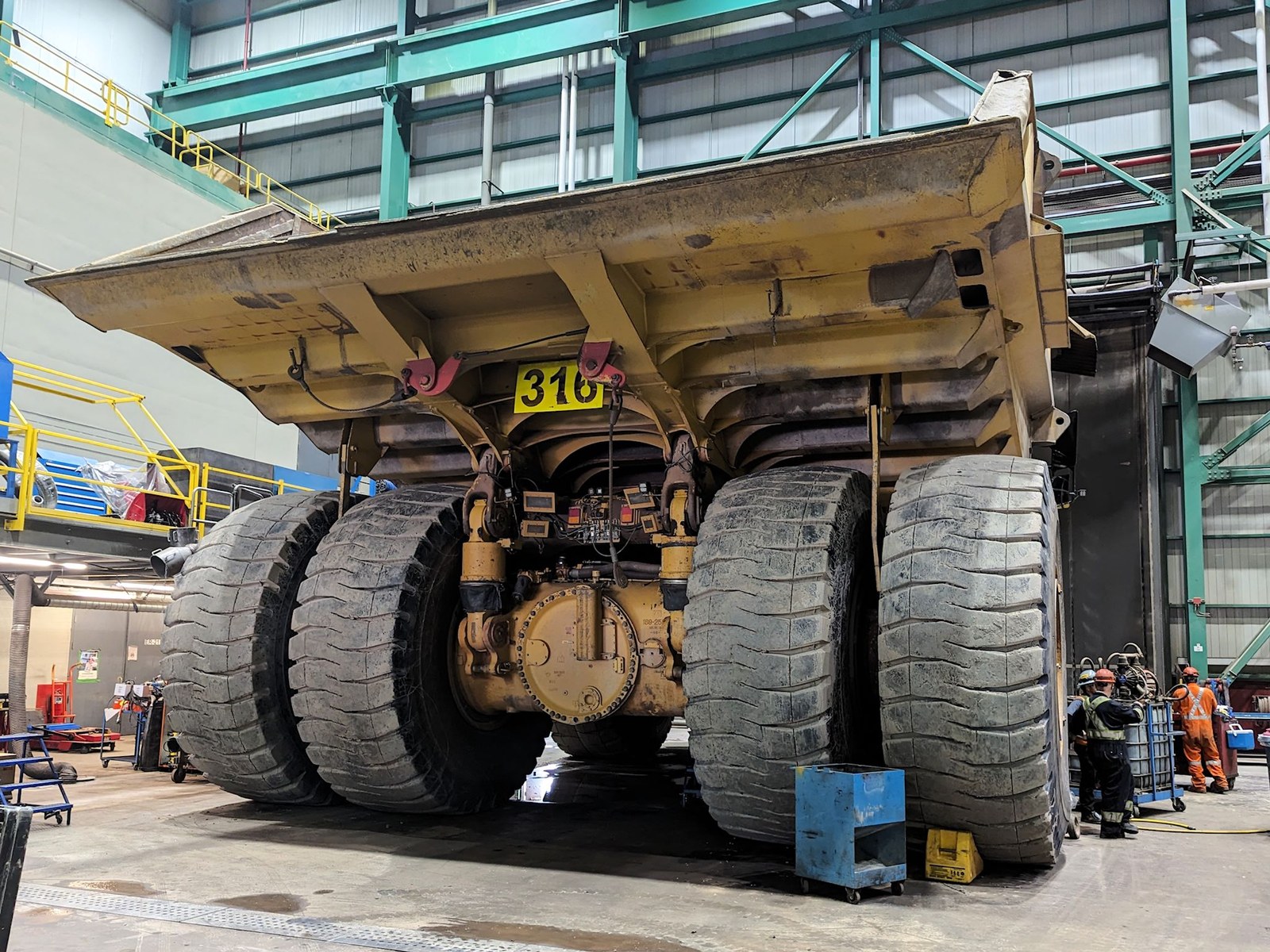 Mining haul truck in the workshop at Mont Wright Mine with wheels off and brake and final drive parts exposed during scheduled maintenance